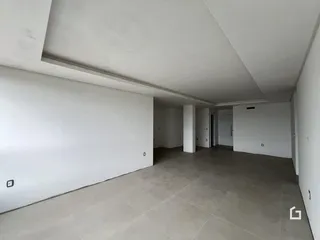 Vista interna de um corredor com paredes brancas e piso cinza.