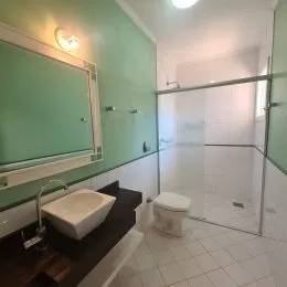 Banheiro com piso de cerâmica e bancada branca.