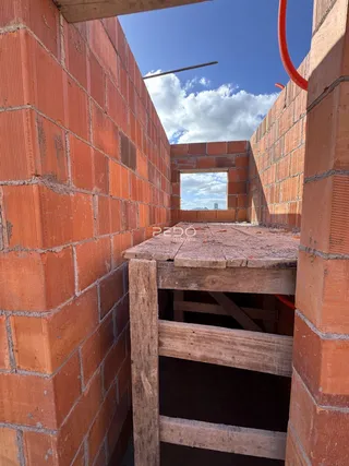 Parede de tijolos vermelhos expostos em uma estrutura de construção.