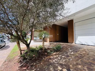 Vista da fachada de uma residência com jardim e garagem em Lajeado.