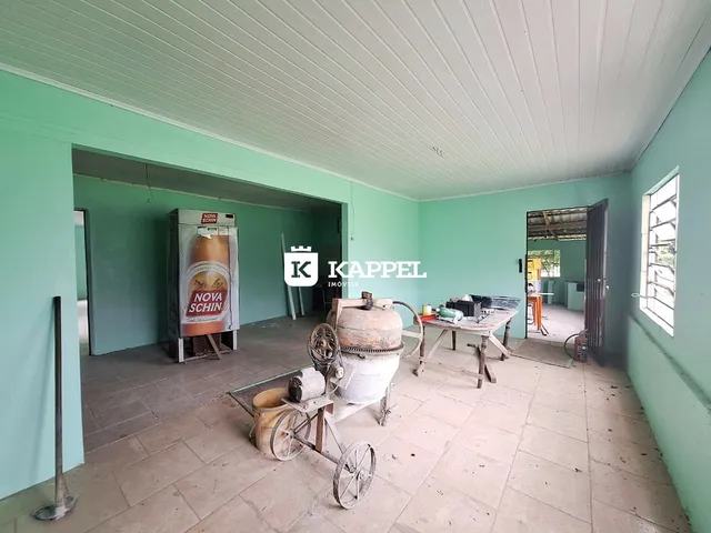 Foto interna de um cômodo com elementos rústicos e paredes verdes.