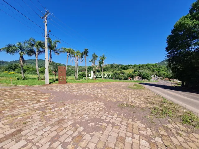 Vista externa de um terreno pavimentado com árvores e uma estrada no Brasil.