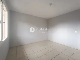 Ambiente interno de uma sala com piso de cerâmica clara e paredes brancas.
