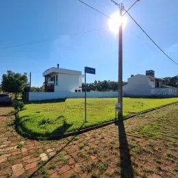 Vista externa de uma propriedade com gramado e uma casa branca.