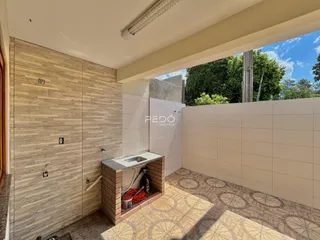 Vista interna de uma área com revestimento de parede e pia em um imóvel.