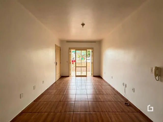 Corredor interno com piso de cerâmica e porta de saída para o exterior.