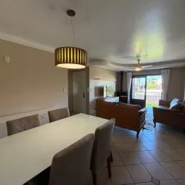 Foto de uma sala de jantar com mesa e cadeiras.