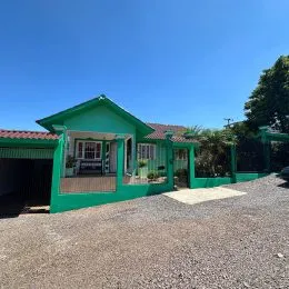 Fachada de uma casa verde com varanda em Lajeado, Brasil.