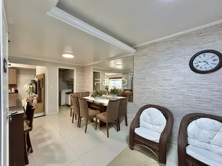 Ambiente de jantar com mesa e assentos em uma sala de estar moderna.