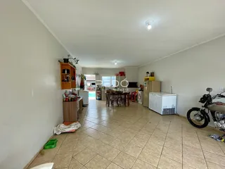 Interior de uma sala de estar com área de jantar e cozinha em Lajeado.