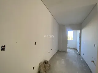 Corredor interno de uma residência com paredes brancas e piso de concreto aparente.