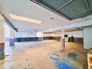 Foto de um espaço interno amplo e vazio com teto exposto.