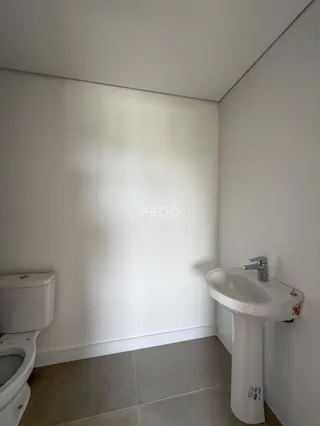 Um canto de banheiro com vaso sanitário e pia.
