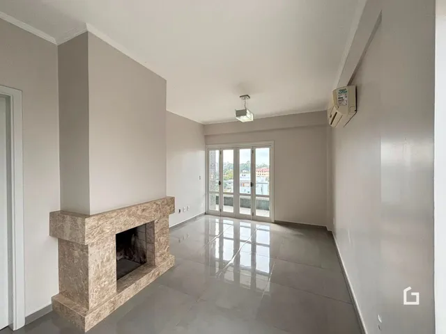 Sala de estar com lareira e piso de cerâmica em um imóvel.