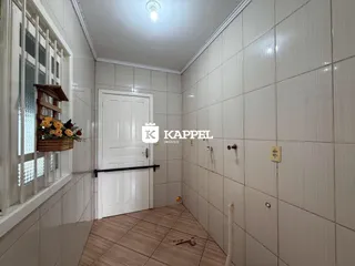 Hall de corredor com paredes brancas e piso de cerâmica.