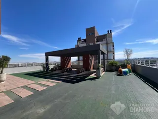 Área externa com pergolado e vista panorâmica da paisagem urbana.