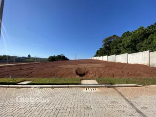 Vista da propriedade mostrando uma encosta de terra e um muro de contenção.