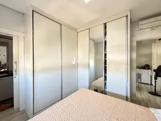 Quarto com armários embutidos brancos e cama na frente.