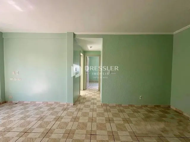 Um corredor com paredes verdes e piso de cerâmica.