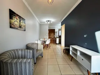 Ambiente interno de uma sala de estar com piso de cerâmica e móveis.