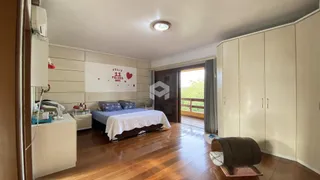 Quarto com cama e armários em madeira no imóvel.