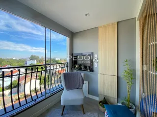 Vista da sala com vista para a paisagem externa através de uma grande janela.