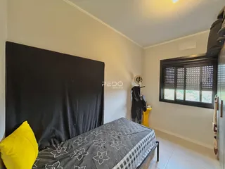 Quarto com cama e janela em ambiente claro.