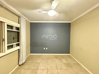 Sala de estar com paredes bege e piso de cerâmica clara.