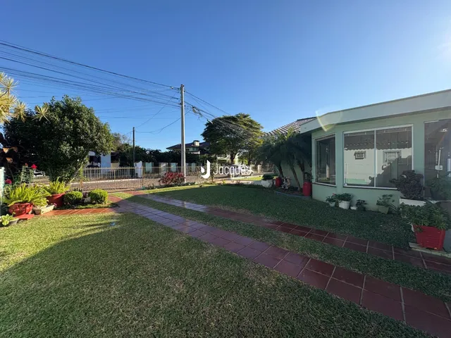 Fachada de uma residência em Lajeado, Brasil, com jardim gramado e paisagismo.