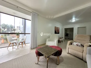 Sala de estar com grandes janelas e móveis de sala.