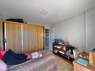 Quarto com armários de madeira e cama no interior de uma residência.