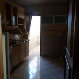 Hall de entrada com armários de madeira e piso de cerâmica.
