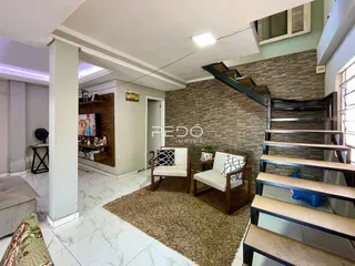 Sala de estar com piso de porcelanato e escadaria em um apartamento em Lajeado.