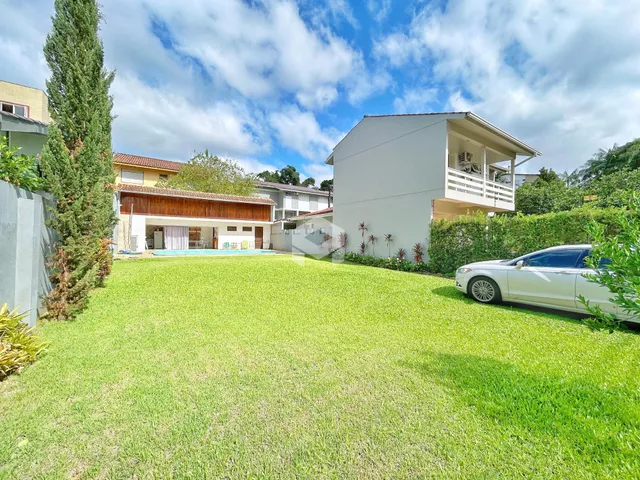 Fachada de uma residência com jardim e piscina em Lajeado, Brasil.