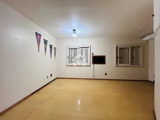 Sala de estar com piso de madeira e paredes brancas.