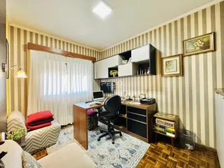 Sala de estar com piso de madeira e decoração de parede listrada.
