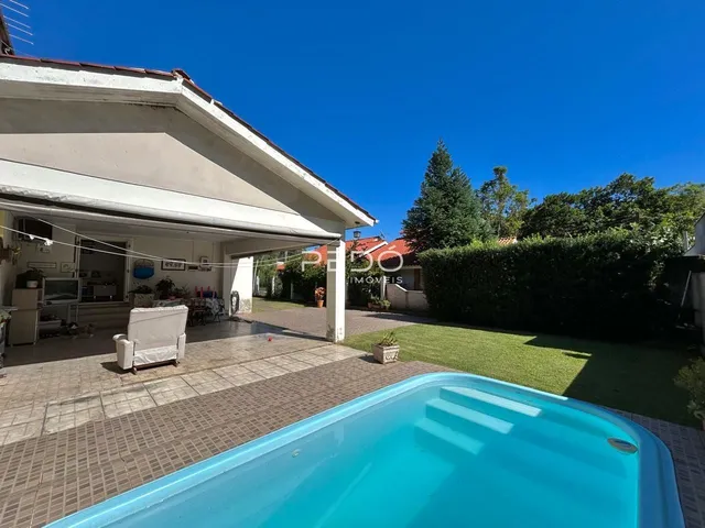 Fachada de uma casa em Lajeado com piscina e jardim.