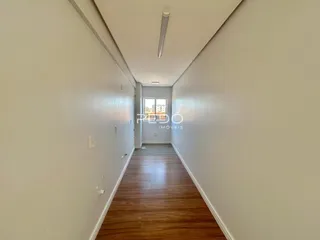 Corredor interno de uma residência com piso de madeira.