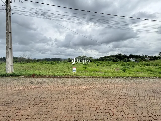 Vista externa de uma propriedade com gramado e área pavimentada.