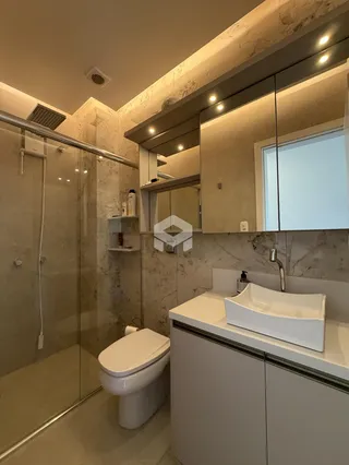 Foto de um banheiro moderno com box de vidro e revestimento em mármore.