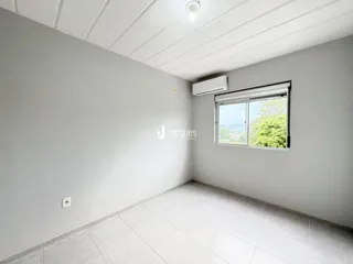 Parede interna de um imóvel com piso de cerâmica clara.