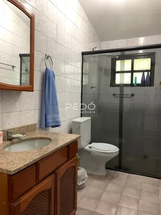 Foto de um banheiro com bancada e box de vidro.