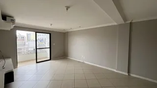 Sala de estar com piso de cerâmica e grande janela de vista urbana.