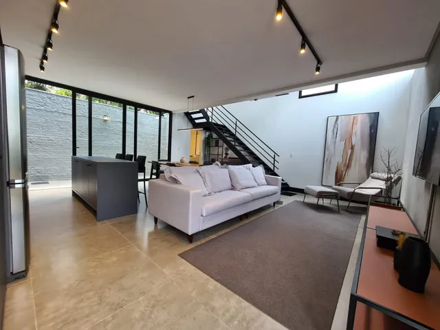 Sala de estar com sofá branco e piso de cerâmica em um imóvel em Lajeado.