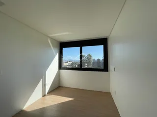Ambiente interno com paredes brancas e piso de madeira.