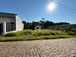 Fachada de uma residência moderna em Lajeado, Brasil, com jardim e área pavimentada.