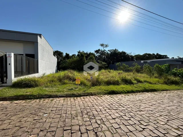 Fachada de uma residência moderna em Lajeado, Brasil, com jardim e área pavimentada.