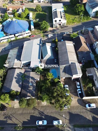 Vista aérea de um complexo residencial com telhados e uma piscina azul no centro.