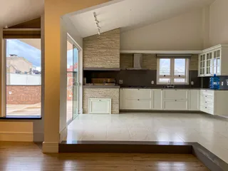 Foto de uma cozinha com armários brancos e piso claro em um imóvel.