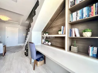Ambiente interno com escadaria e estantes de madeira em um apartamento.